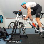 İç mekânda trainer üzerinde Zwift ile bisiklet antrenmanı yapan sporcu