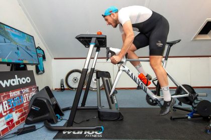 İç mekânda trainer üzerinde Zwift ile bisiklet antrenmanı yapan sporcu