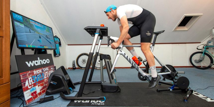 İç mekânda trainer üzerinde Zwift ile bisiklet antrenmanı yapan sporcu